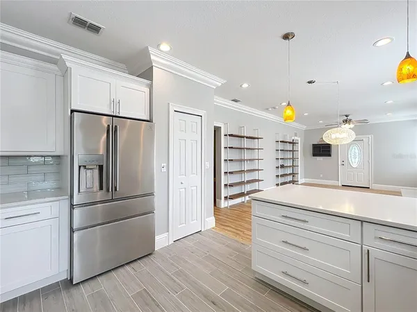 a kitchen with stainless steel appliances kitchen island granite countertop a refrigerator a stove a sink and a center island