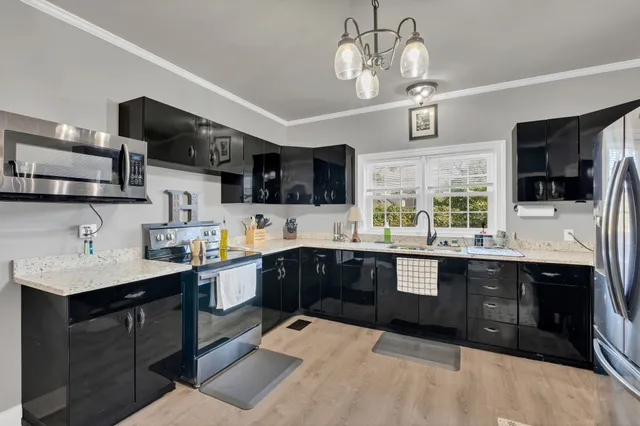 a kitchen with stainless steel appliances granite countertop a sink and dishwasher a stove top oven with wooden floor