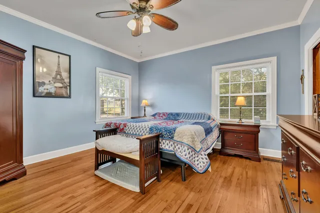 a bedroom with a bed and wooden floor