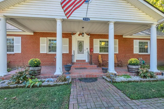 a front view of a house with a yard outdoor seating and mountain view