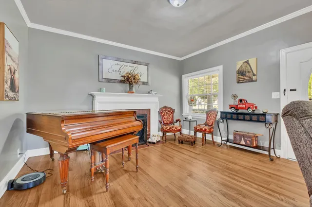 a living room with furniture a dining table and a piano next to a window
