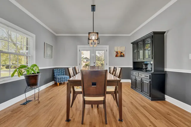 a dining room with furniture a window and wooden floor
