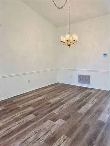 a view of a room with wooden floor and ceiling fan