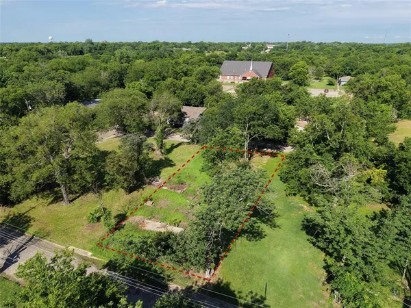 an aerial view of a houses with a yard and lake