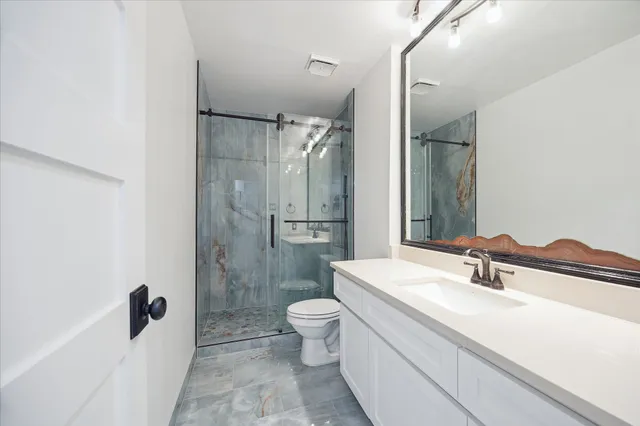 a bathroom with a sink a toilet and shower