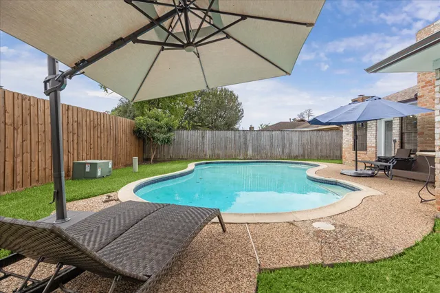 a view of a backyard with a patio and swimming pool