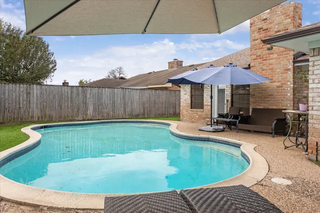 a view of a backyard with swimming pool and furniture