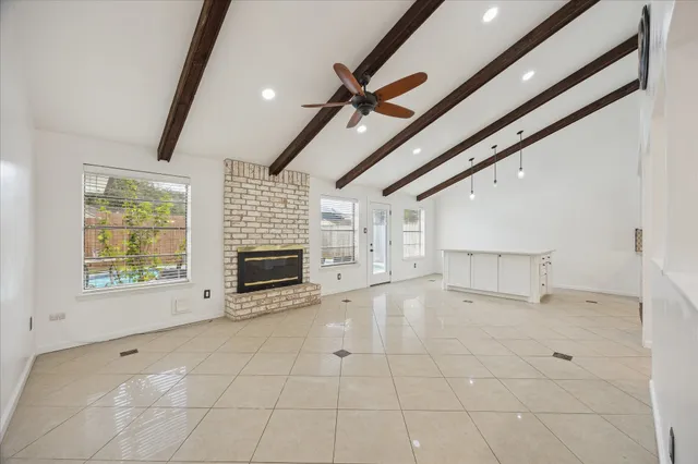a view of an empty room with a fireplace and a window