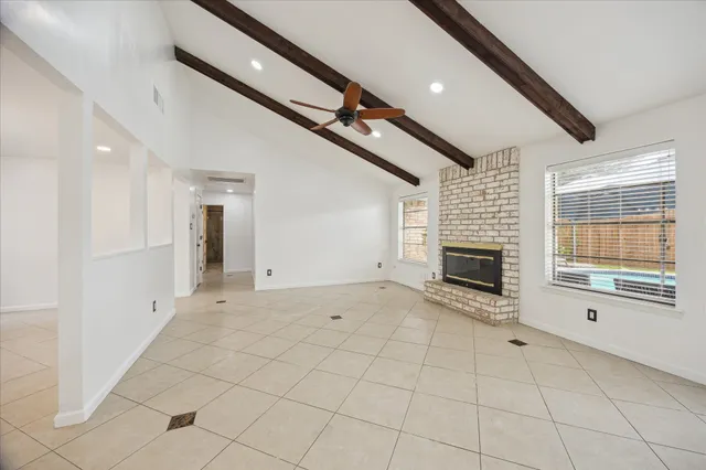 a view of an empty room with a fireplace and a window