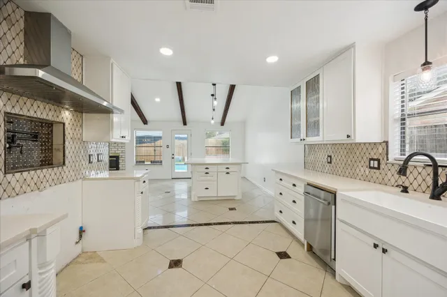 a large white kitchen with cabinets