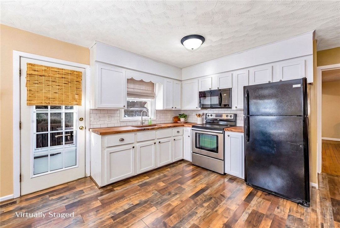 2862 Lower Nettle Knob Road West Jefferson, NC 28694 - Photo 18 of 48 a kitchen with granite countertop stainless steel appliances a refrigerator a stove a sink and a window