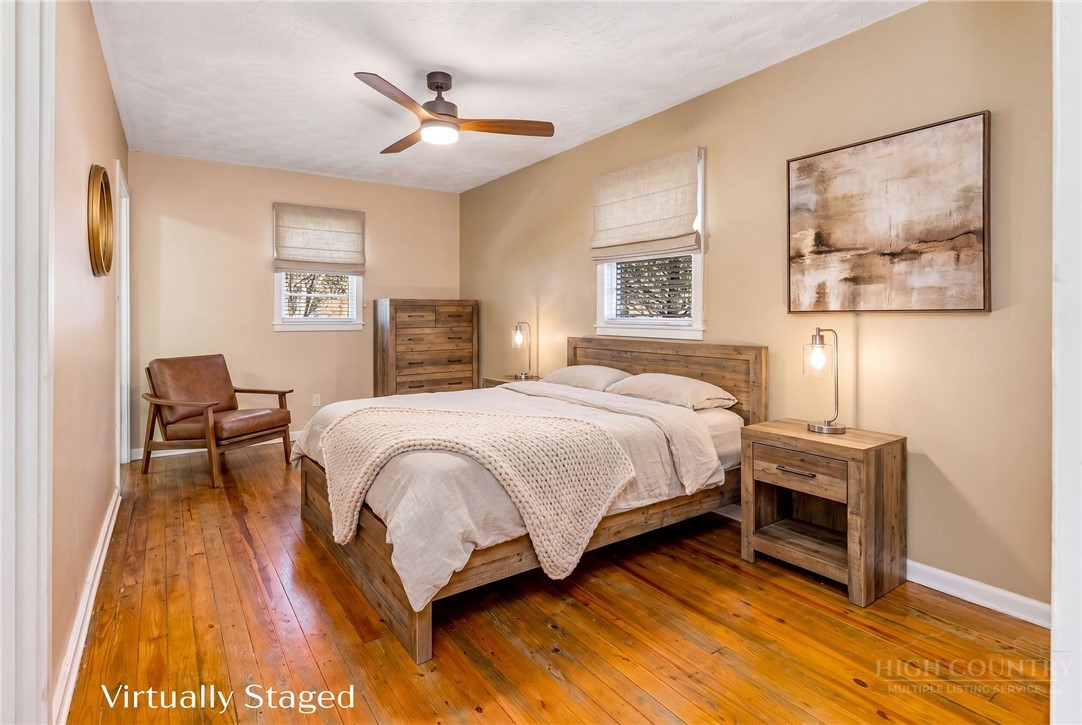 2862 Lower Nettle Knob Road West Jefferson, NC 28694 - Photo 19 of 48 a spacious bedroom with a bed a table and painting on the wall