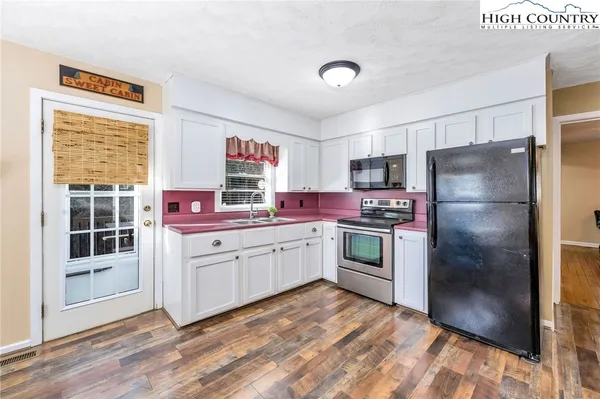 a kitchen with granite countertop stainless steel appliances a refrigerator and a stove top oven