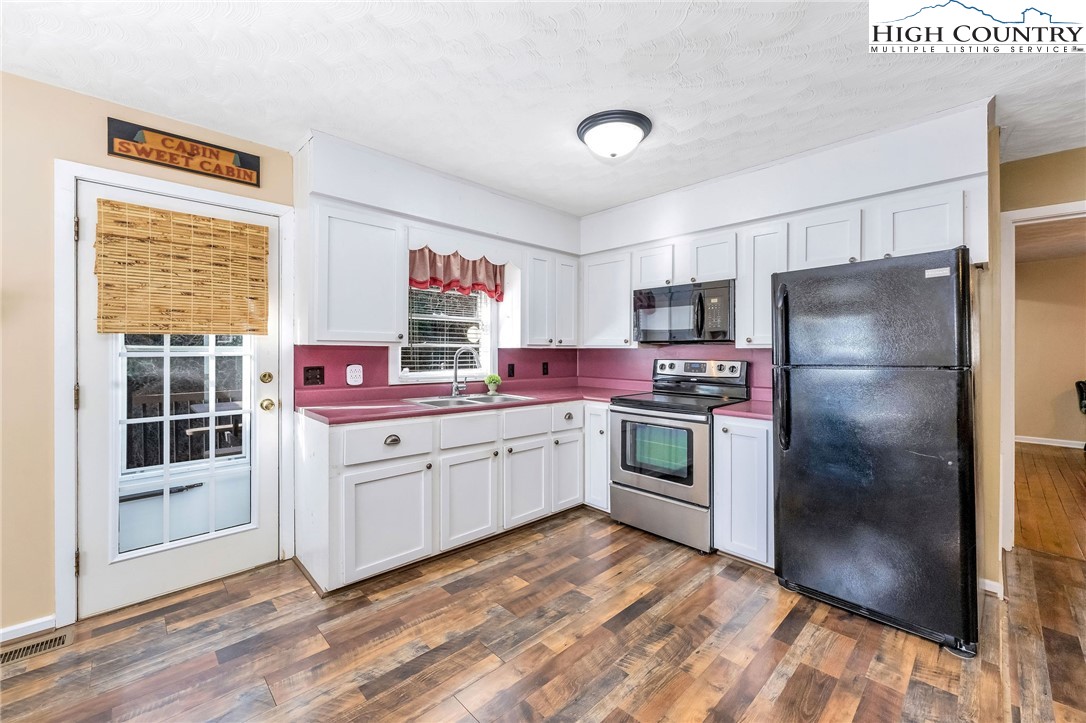 2862 Lower Nettle Knob Road West Jefferson, NC 28694 - Photo 19 of 41 a kitchen with granite countertop stainless steel appliances a refrigerator and a stove top oven