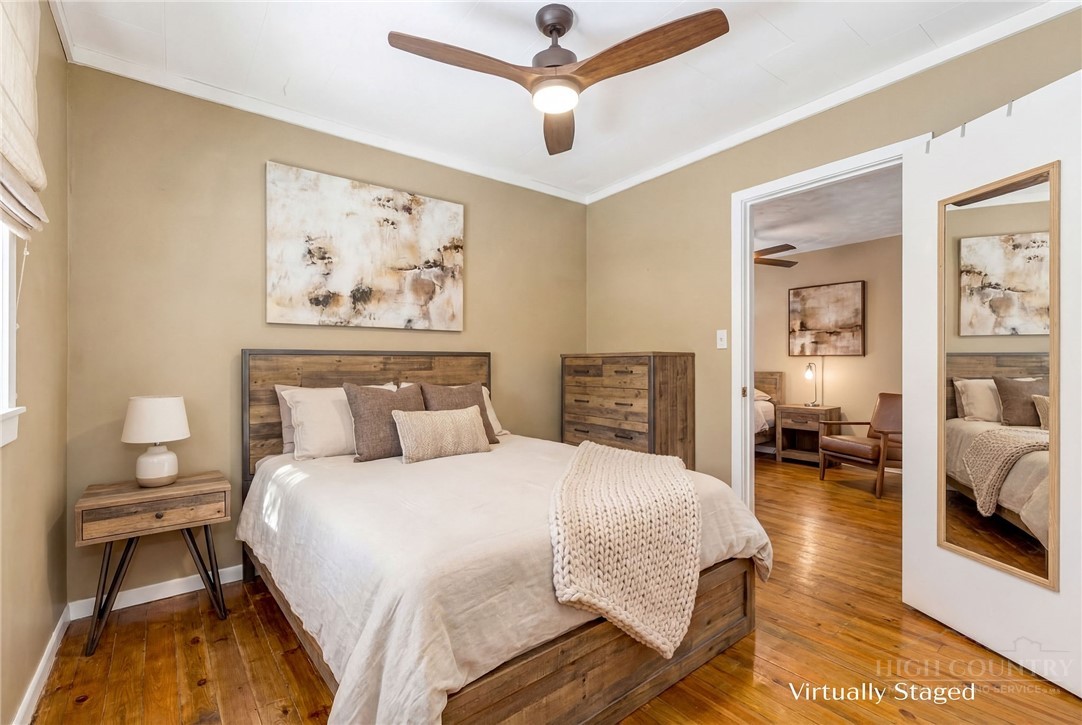 2862 Lower Nettle Knob Road West Jefferson, NC 28694 - Photo 20 of 48 a bedroom with a bed and a chandelier