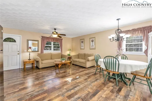 a living room with furniture wooden floor and a chandelier