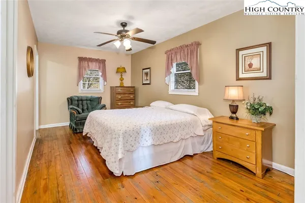 a bedroom with a large bed a chandelier and a potted plant