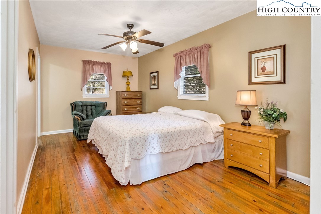 2862 Lower Nettle Knob Road West Jefferson, NC 28694 - Photo 25 of 41 a bedroom with a large bed a chandelier and a potted plant