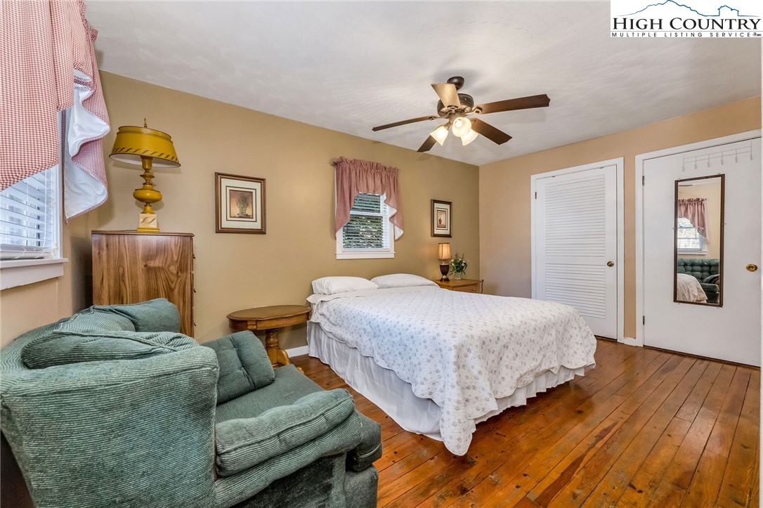 2862 Lower Nettle Knob Road West Jefferson, NC 28694 - Photo 31 of 48 a spacious bedroom with a bed and a chandelier