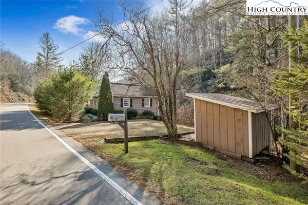 a view of a house with backyard and trees