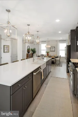 a large kitchen with kitchen island a sink stainless steel appliances and a chandelier
