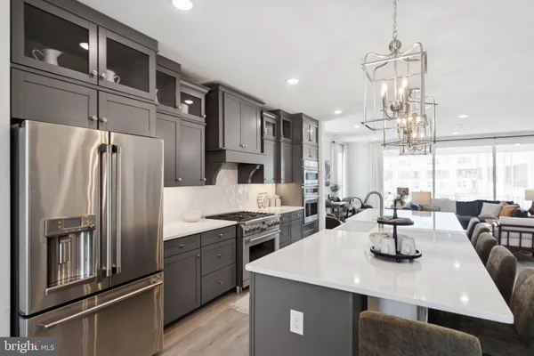 a kitchen with stainless steel appliances a sink a stove a refrigerator and cabinets