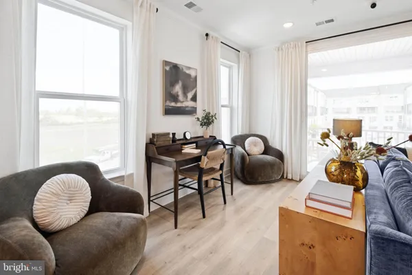 a living room with furniture ceiling fan and a window