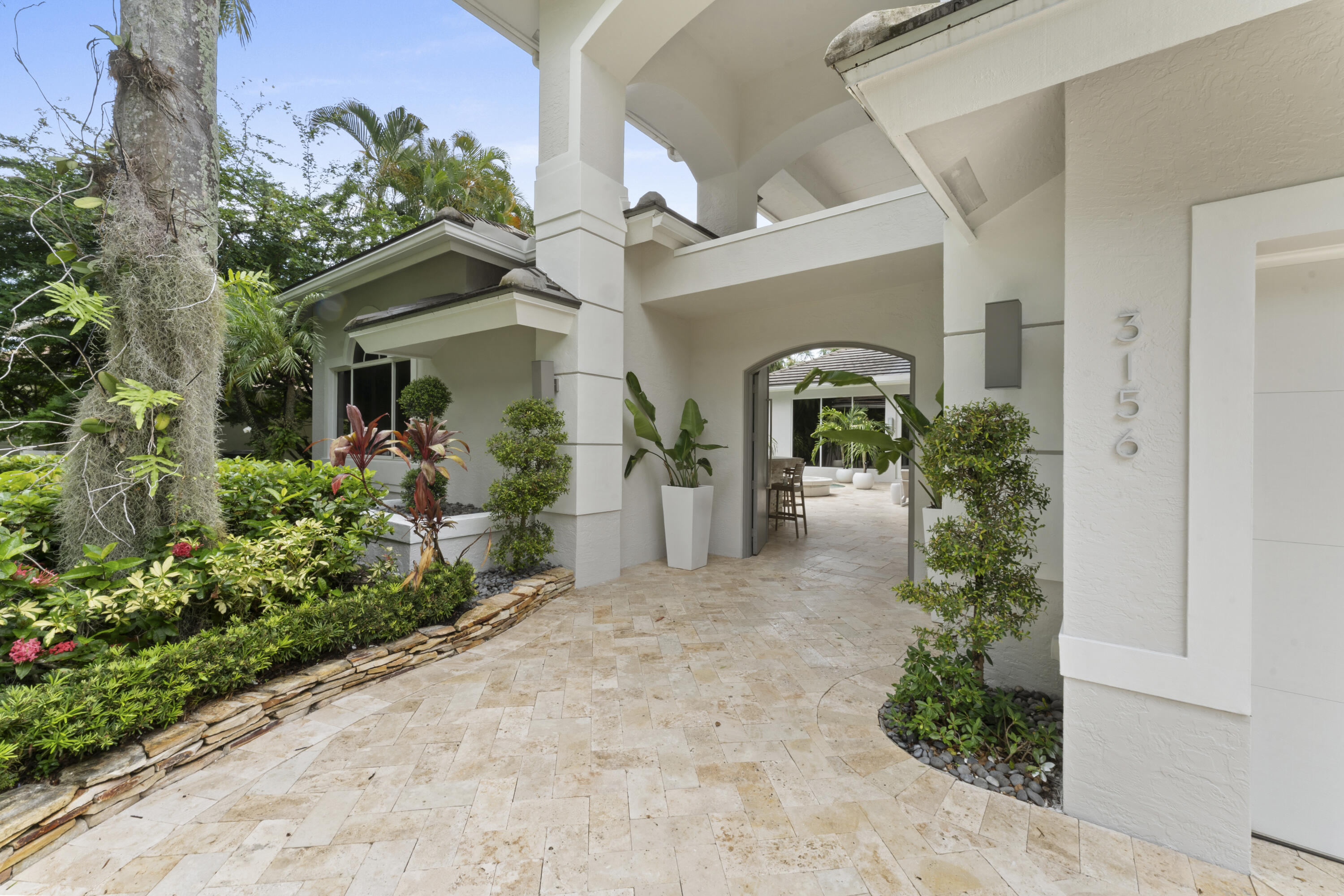 3156 Northwest 61st Street Boca Raton, FL 33496 - Photo 3 of 46 a front view of a house with lots of yellow lighting