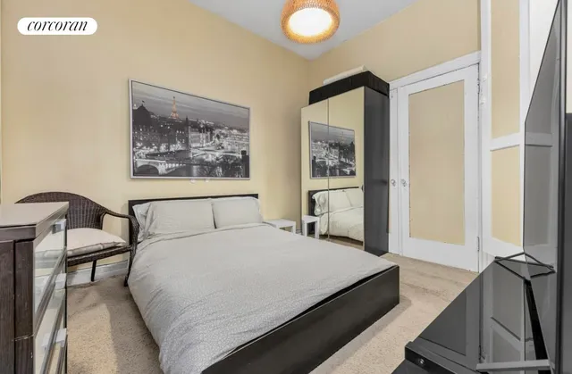 a bedroom with a bed and a painting on the wall