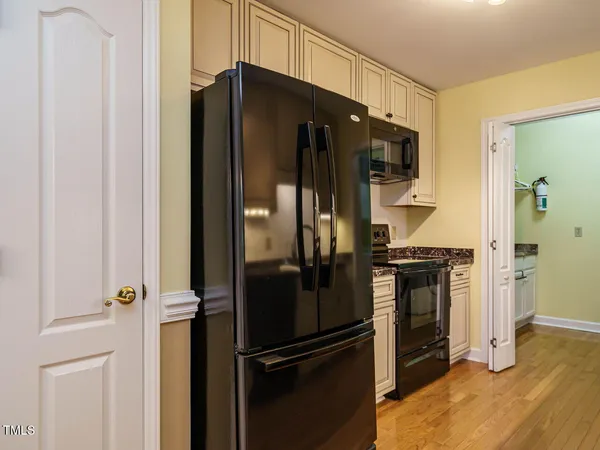 a kitchen with a refrigerator and a stove top oven