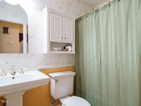 a bathroom with a sink a toilet and a mirror