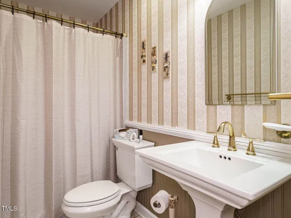 a bathroom with a sink a toilet and shower curtain
