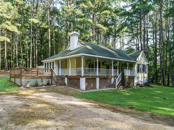a view of a house with a yard and sitting area