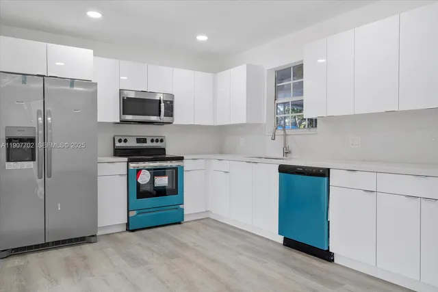 a kitchen with stainless steel appliances a refrigerator sink and microwave