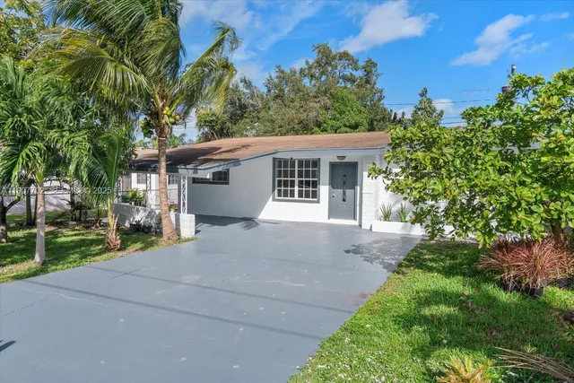 a view of a house with a yard and potted plants