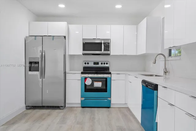 a kitchen with a refrigerator sink and cabinets