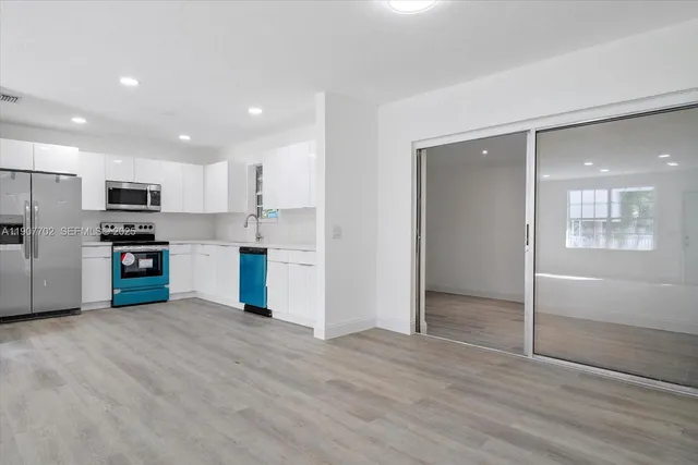 a kitchen with stainless steel appliances kitchen island granite countertop a refrigerator and a sink