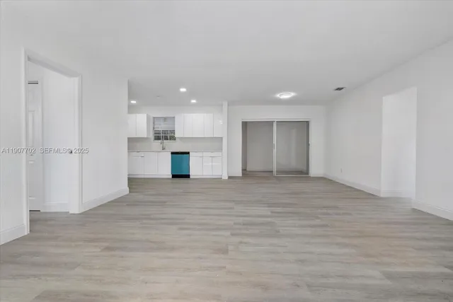 a view of a kitchen with a refrigerator and a sink