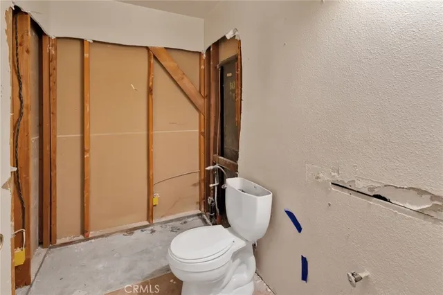 a white toilet sitting next to a bathroom sink and a shower