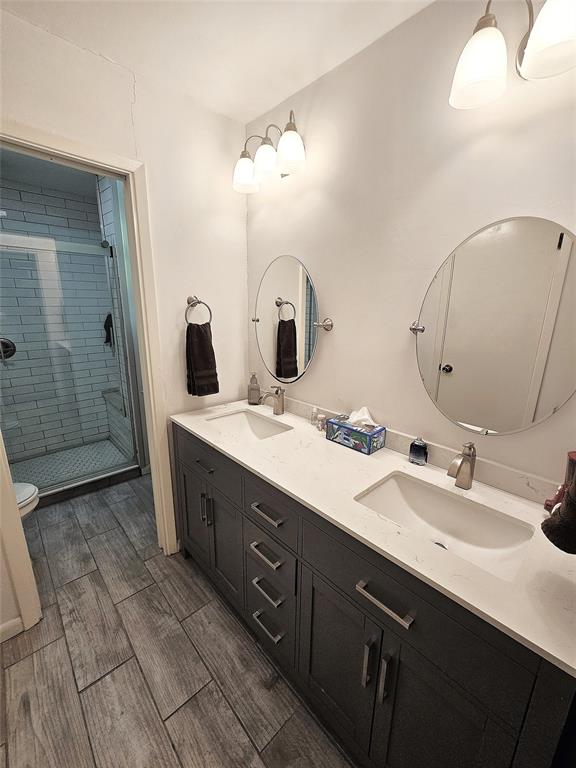 220 North Calhoun Street Groesbeck, TX 76642 - Photo 13 of 24 a bathroom with a double vanity sink mirror and shower