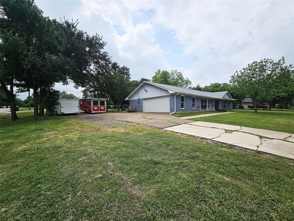 220 North Calhoun Street Groesbeck, TX 76642 - Photo 3 of 24 a view of a house with a big yard and large trees