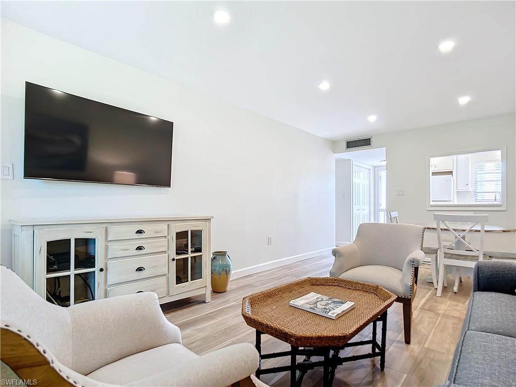 180 Turtle Lake Court, Unit 206 Naples, FL 34105 - Photo 25 of 50 a living room with furniture and a flat screen tv