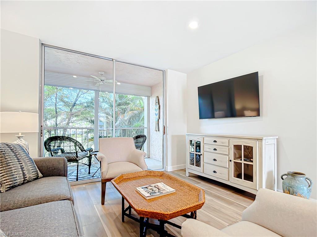 180 Turtle Lake Court, Unit 206 Naples, FL 34105 - Photo 26 of 50 a living room with furniture and a flat screen tv