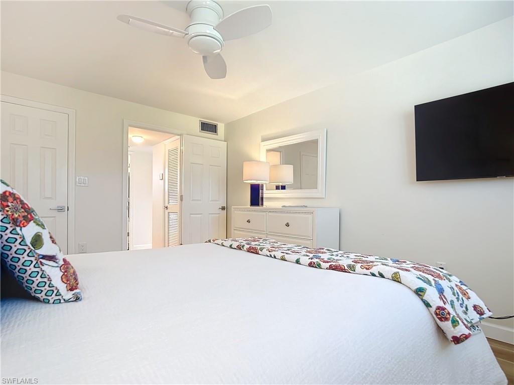 180 Turtle Lake Court, Unit 206 Naples, FL 34105 - Photo 27 of 50 a bedroom with a bed and a flat screen tv