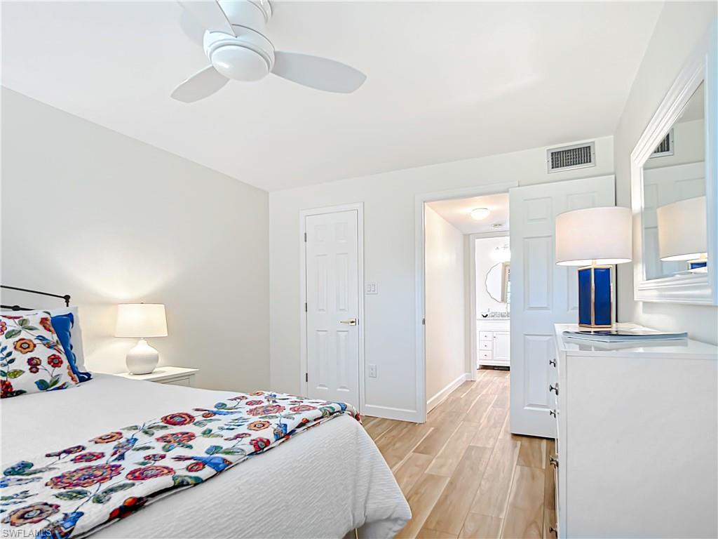 180 Turtle Lake Court, Unit 206 Naples, FL 34105 - Photo 28 of 50 a bedroom with a bed and a chandelier