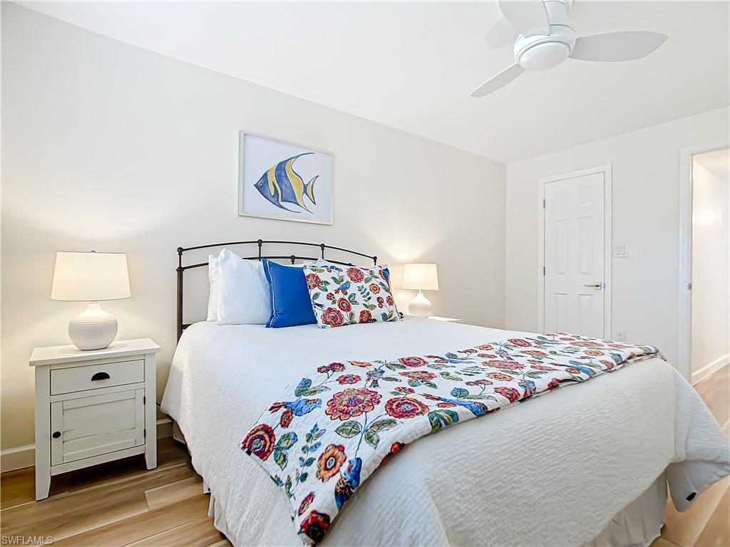 180 Turtle Lake Court, Unit 206 Naples, FL 34105 - Photo 29 of 50 a bedroom with a bed and a painting on the wall