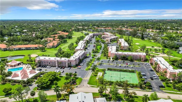 an aerial view of residential houses with outdoor space and trees
