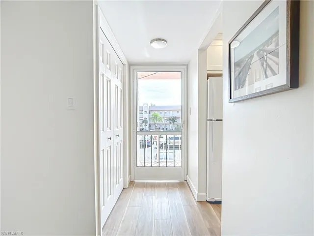 a view of a hallway with wooden floor and windows