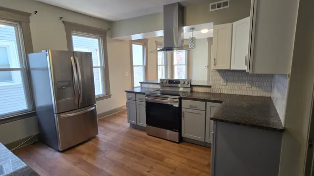 a kitchen with granite countertop a refrigerator stove and sink