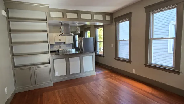 a kitchen with stainless steel appliances granite countertop a refrigerator and a wooden floors